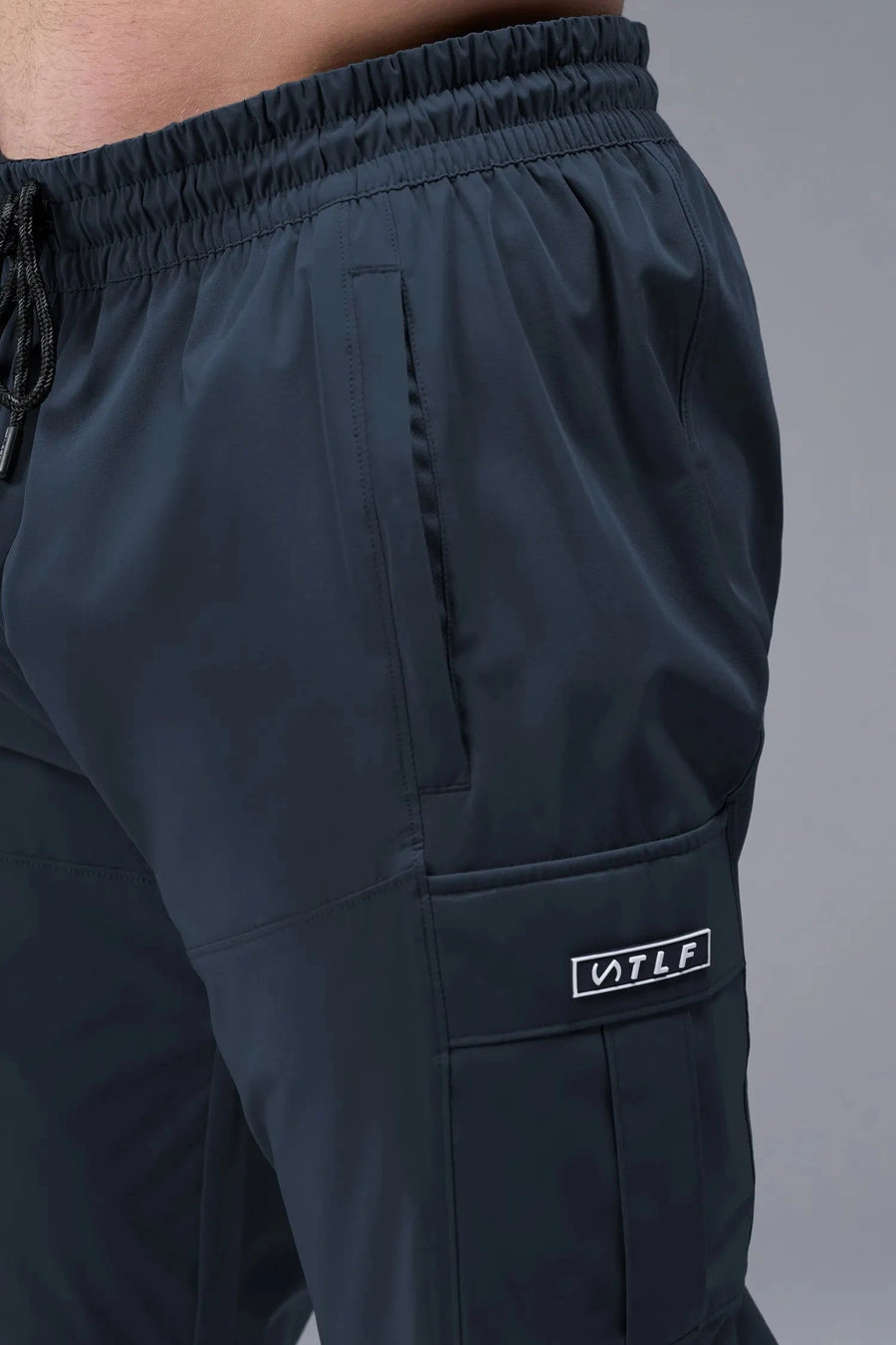 Detail View of Blue TLF Element Athletic Joggers 2.0, featuring side zipper pockets and side leg cargo pockets and reflective details 