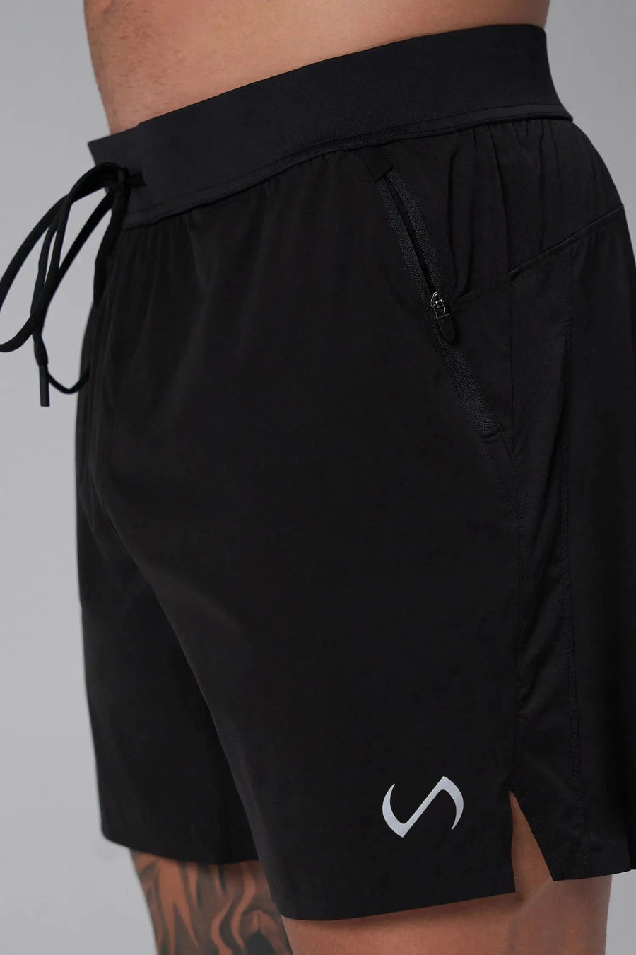 Side View of the Black the TLF Element Light 7 Inch Shorts featuring side zipper pockets, side split hems and reflective details for nighttime visibility