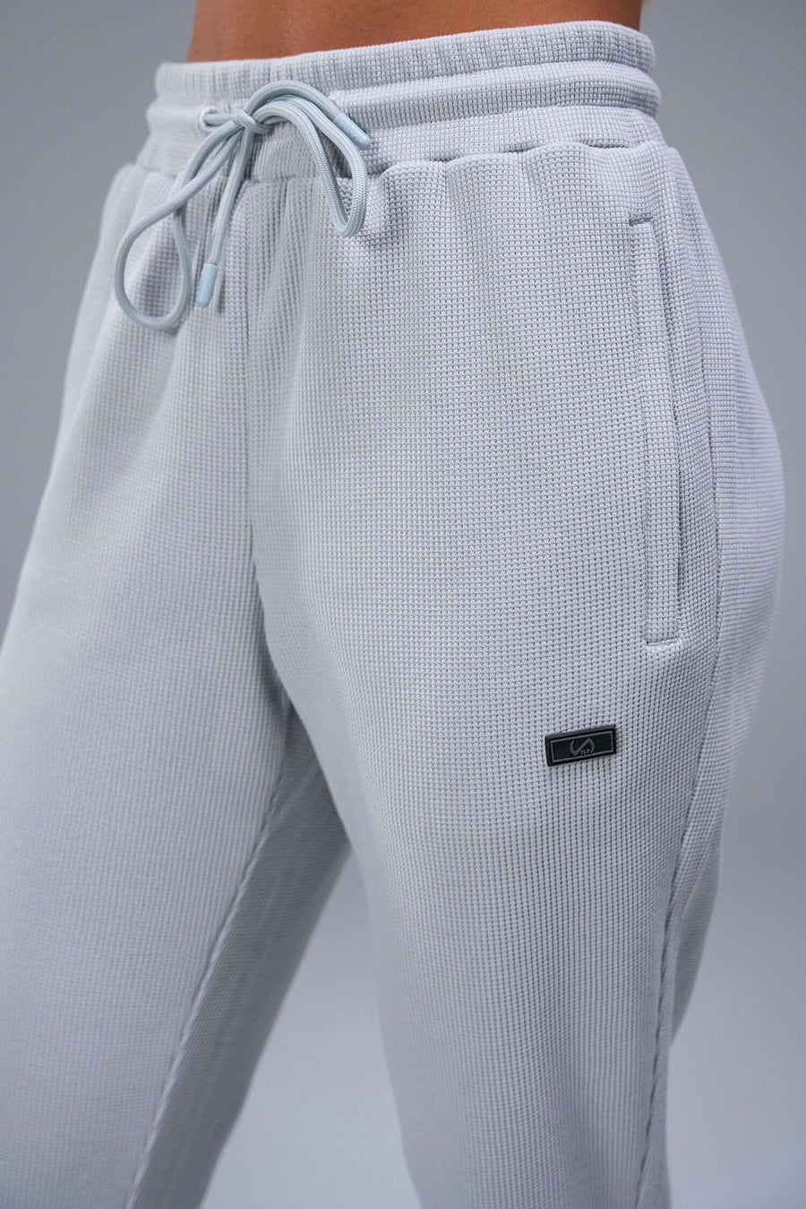 Detail Front View of Gray TLF Elevate Waffle Tech Joggers, featuring an athletic relaxed fit with zipper pockets designed for all day wear