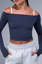 Front View of Blue TLF Essential Seamless off the shoulder top, featuring a cropped length and thumbholes 