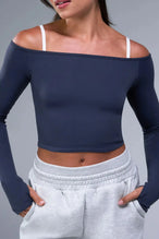 Front View of Blue TLF Essential Seamless off the shoulder top, featuring a cropped length and thumbholes 
