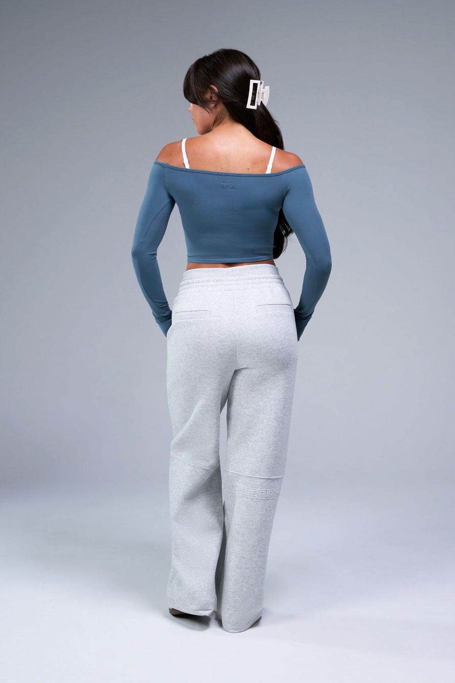 Back View of Blue TLF Essential Seamless off the shoulder top, featuring a cropped length and thumbholes 