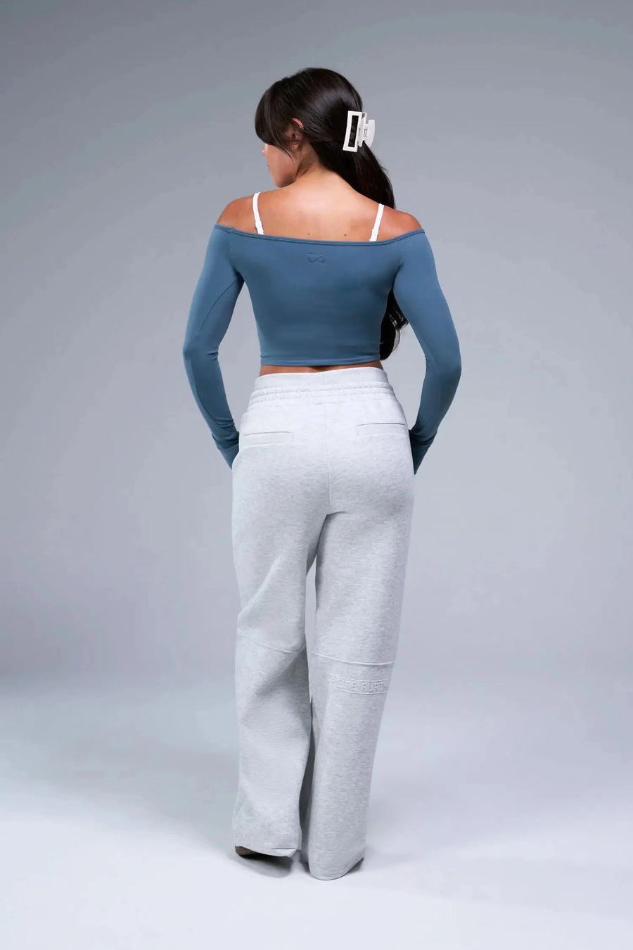 Back View of Blue TLF Essential Seamless off the shoulder top, featuring a cropped length and thumbholes 
