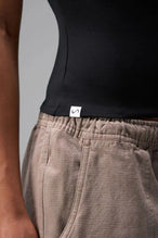 Detail Front View of Black the TLF Fitted Crew Neck T-Shirt featuring a long line silhouette and whip stitch detailing. 