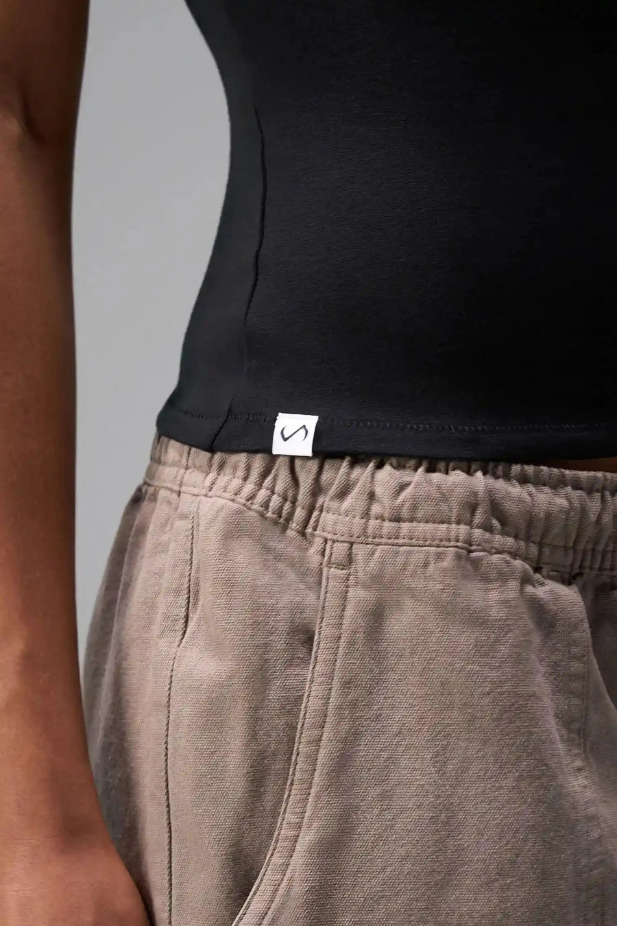 Detail Front View of Black the TLF Fitted Crew Neck T-Shirt featuring a long line silhouette and whip stitch detailing. 