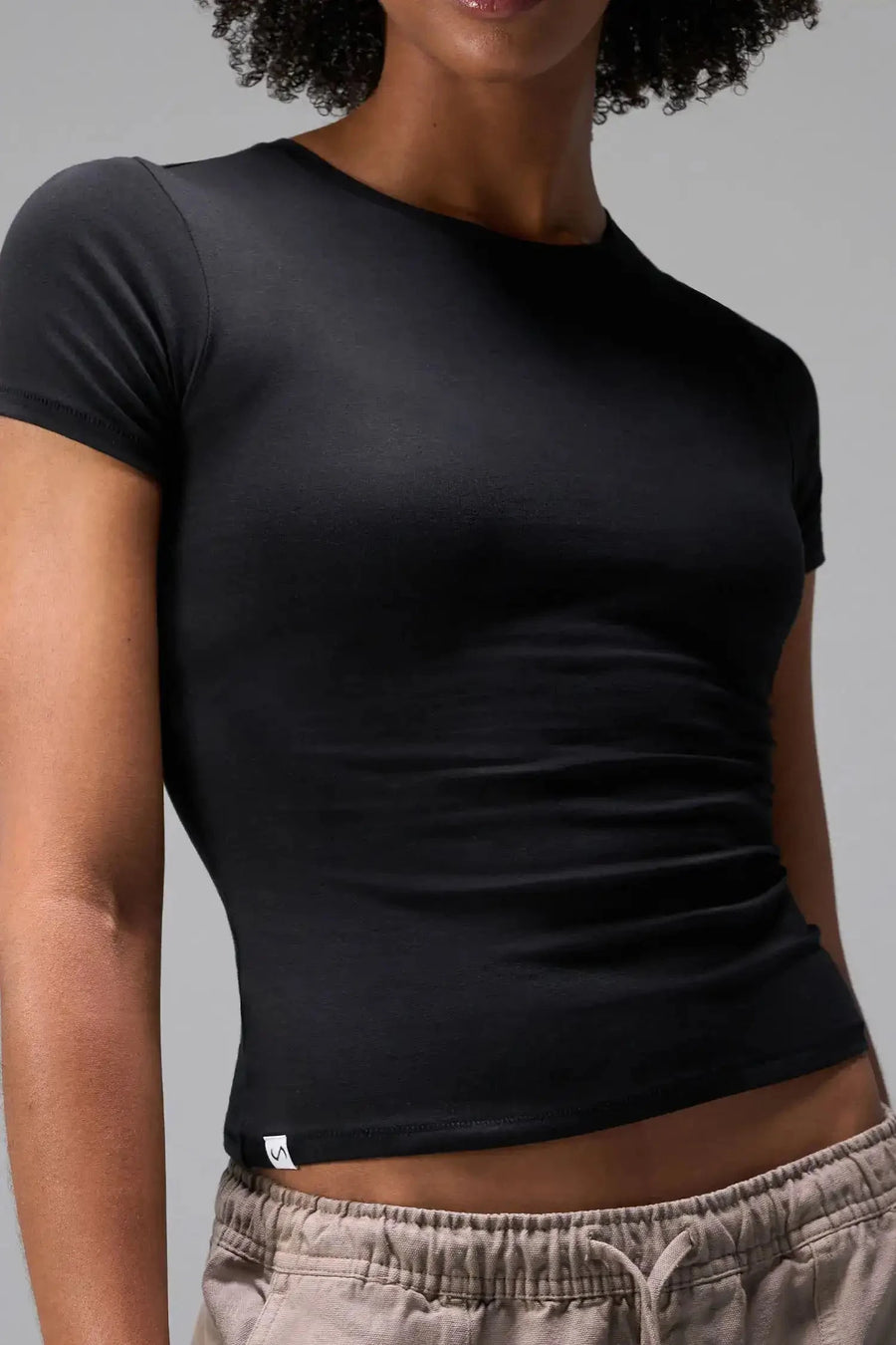 Front View of Black the TLF Fitted Crew Neck T-Shirt featuring a long line silhouette and whip stitch detailing. 