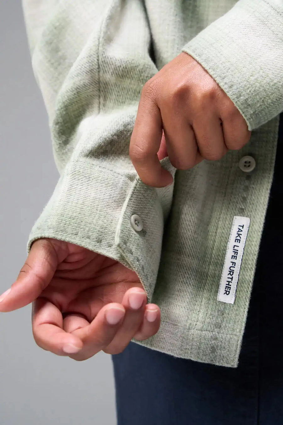 Detail View of the Green TLF Flannel Shacket featuring premium embroidery details on the collar and back in a cotton plaid flannel fabric