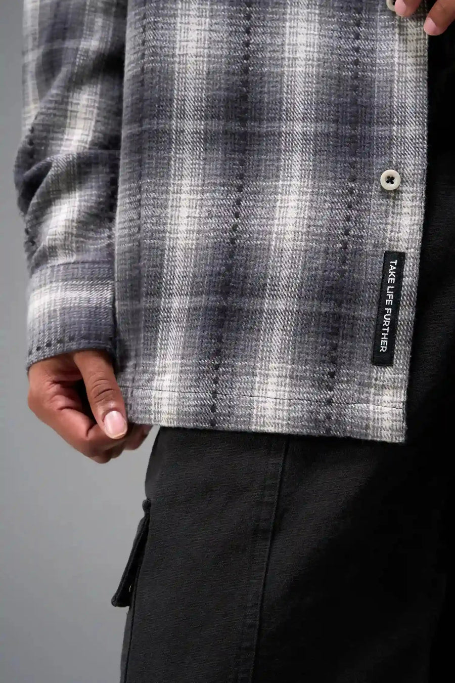 Front Detail View of the Black TLF Flannel Shacket featuring premium embroidery details on the collar and back in a cotton plaid flannel fabric