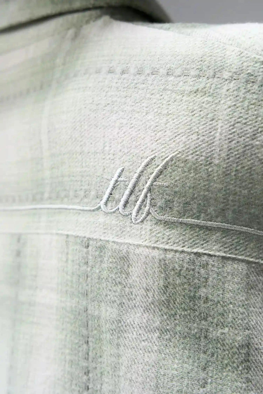 Detail View of the Green TLF Flannel Shacket featuring premium embroidery details on the collar and back in a cotton plaid flannel fabric