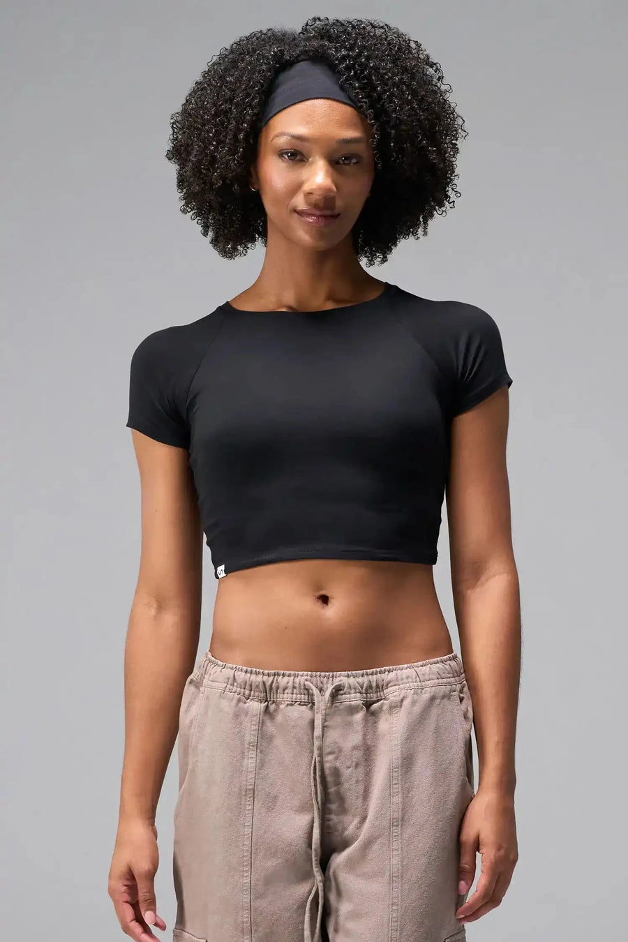 Front View of Black the TLF GTS Cropped Baby Tee features sporty raglan sleeves, cropped length and premium whip stitch detailing. 