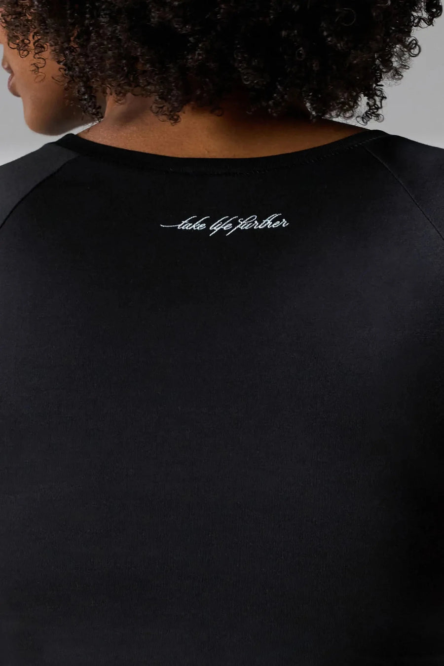 Back View of Black the TLF GTS Cropped Baby Tee features sporty raglan sleeves, cropped length and premium whip stitch detailing. 