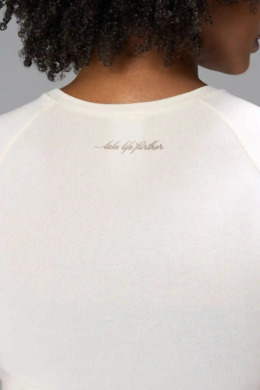 Back View of White the TLF GTS Cropped Baby Tee features sporty raglan sleeves, cropped length and premium whip stitch detailing. 