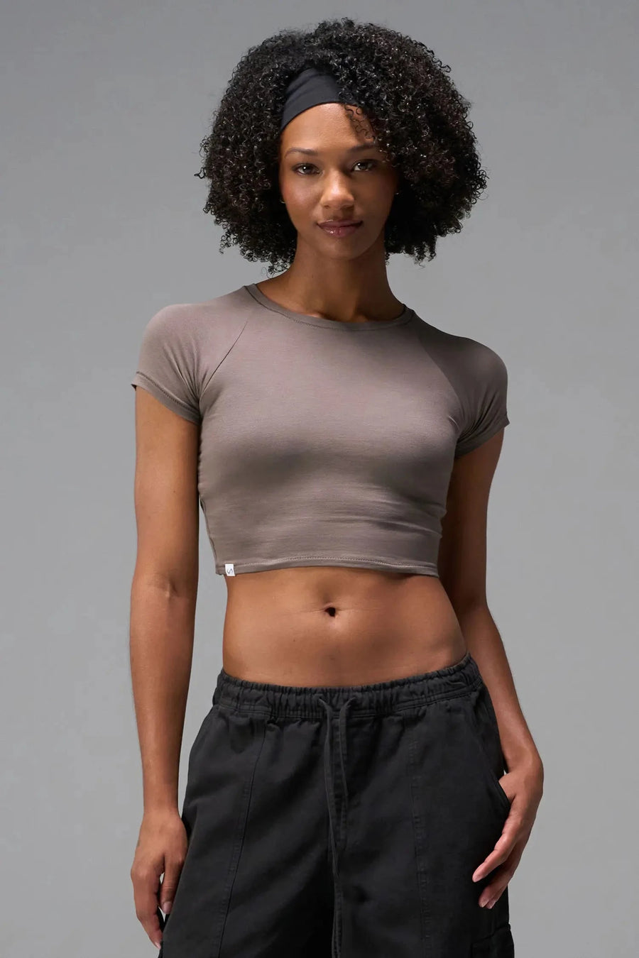 Front View of Brown the TLF GTS Cropped Baby Tee features sporty raglan sleeves, cropped length and premium whip stitch detailing. 