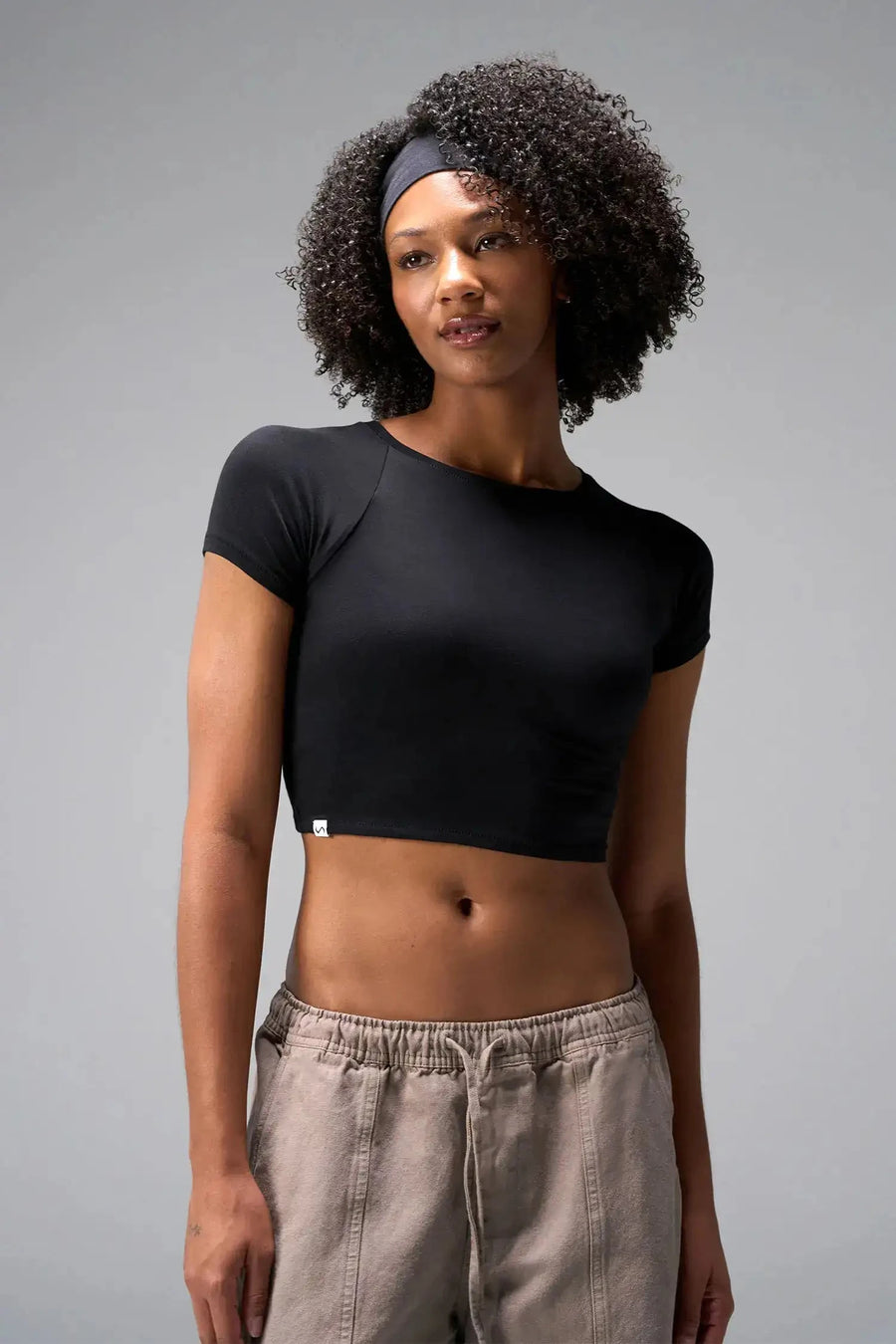 Front View of Black the TLF GTS Cropped Baby Tee features sporty raglan sleeves, cropped length and premium whip stitch detailing. 