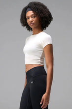Side View of White the TLF GTS Cropped Baby Tee features sporty raglan sleeves, cropped length and premium whip stitch detailing. 