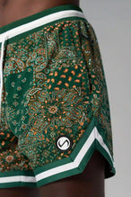 Detail Front View of Green GTS Evolve Mesh 6 Inch Shorts, featuring university of Miami inspired patch paisley design and zipper pockets