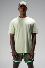 Front View of Green GTS Evolve Mesh 6 Inch Shorts, featuring university of Miami inspired patch paisley design and zipper pockets