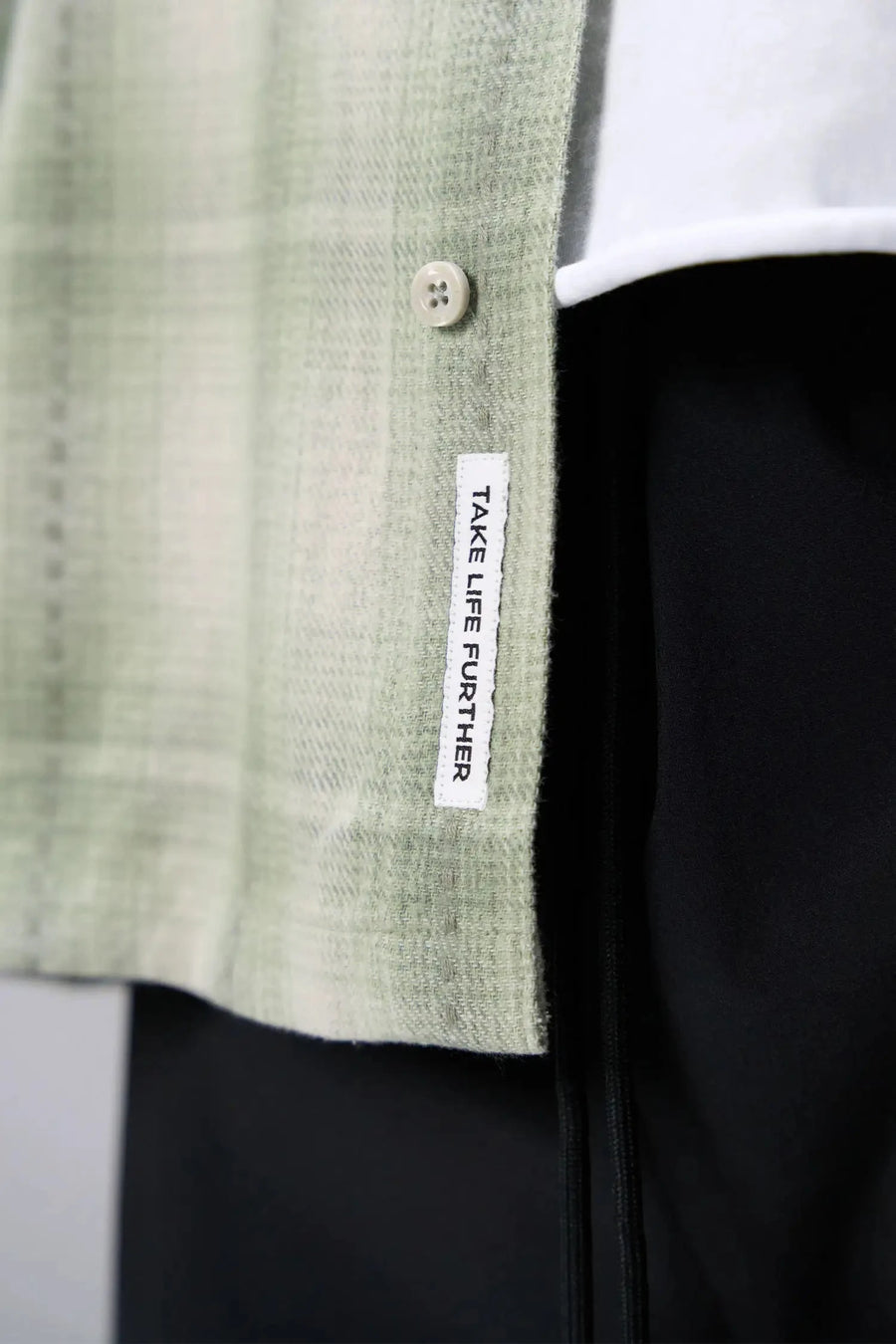 Detail View of the Green TLF GTS Flannel Shacket crafted in premium cotton plaid flannel with elevated embroidery details on the collar and back