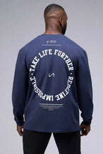 Back View of Blue the TLF Redefine Original Cotton Luxe Oversized LS Tee that features a bold back graphic in an oversized fit. 