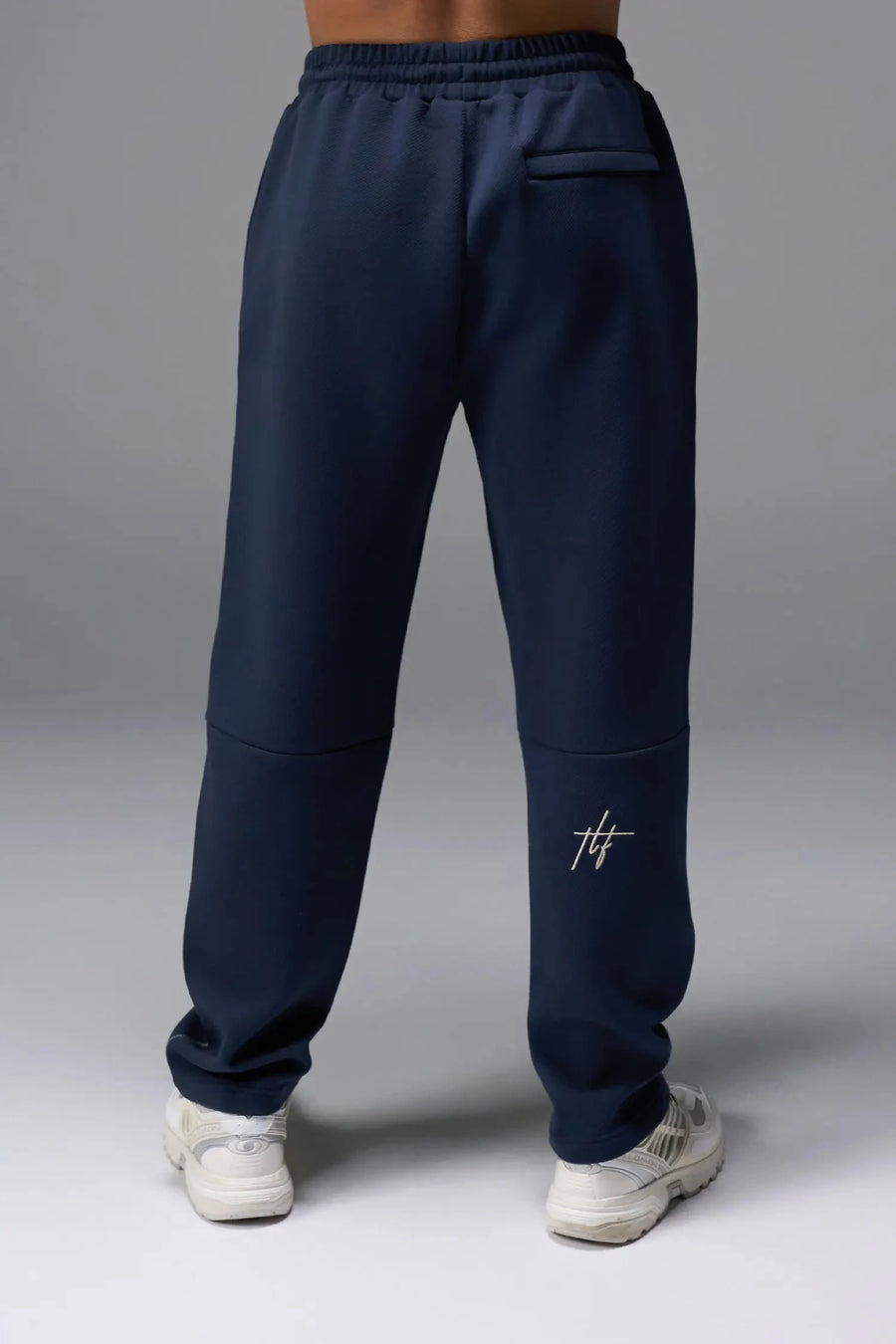 Back View of Blue TLF GTS Twill Tech Joggers, featuring contrast stitching, zippered pockets, and next level style and function