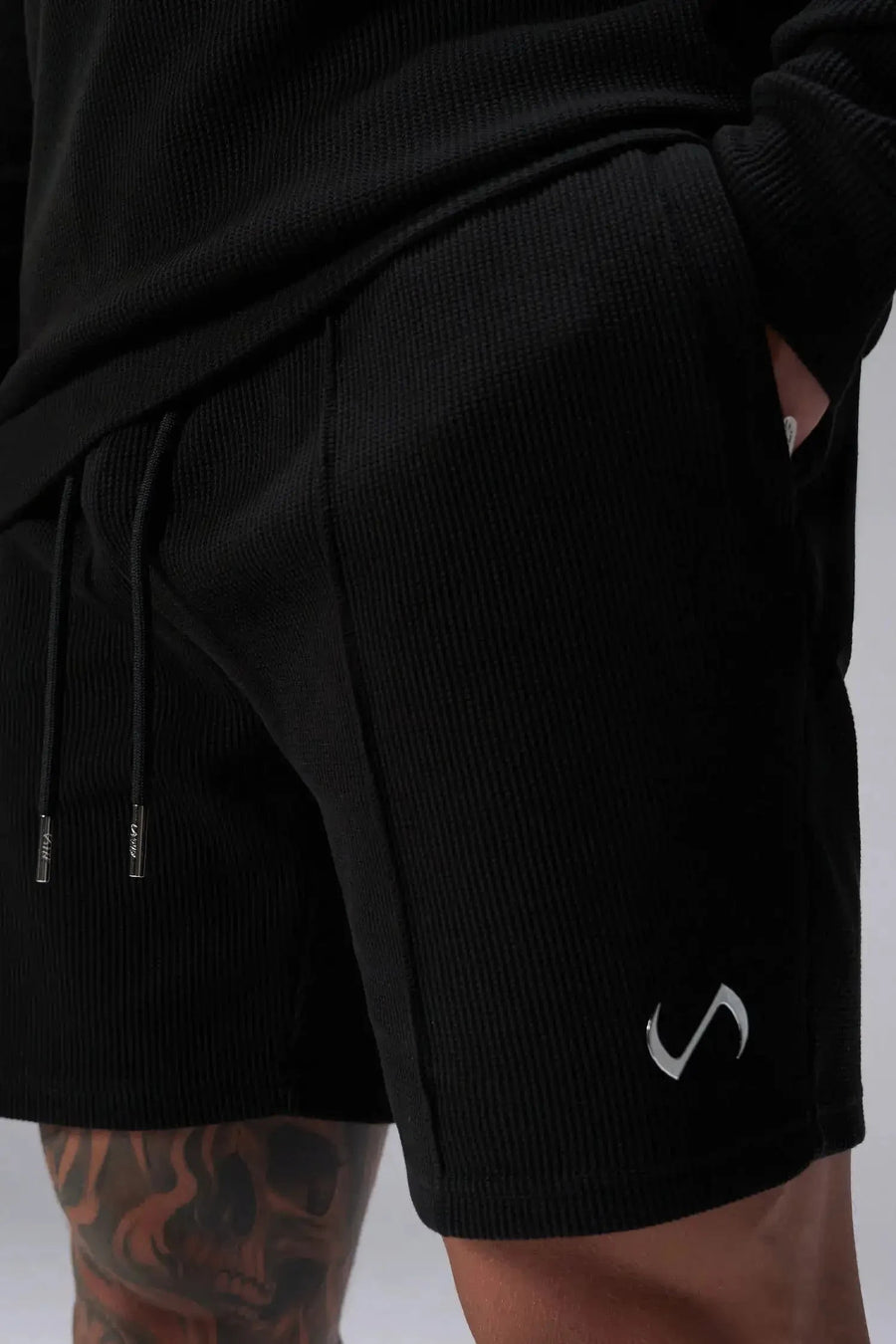 Detail View of Black TLF GTS Waffle Tech Shorts, featuring a 7 Inch inseam, an athletic relaxed fit with zipper pockets designed for all day wear