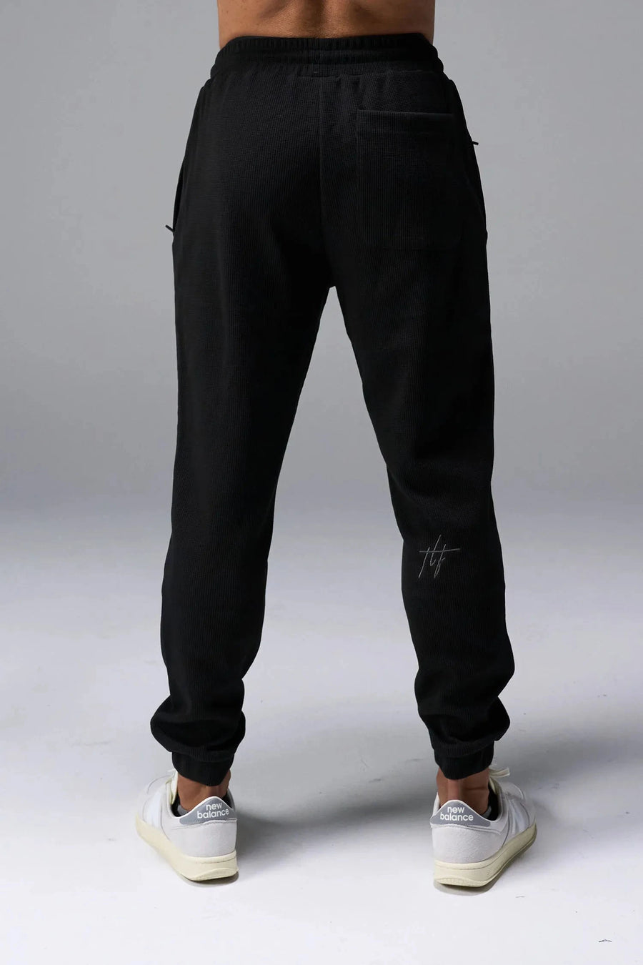 Back View of Black TLF GTS Waffle Tech Joggers, featuring an athletic relaxed fit with zipper pockets designed for all day wear