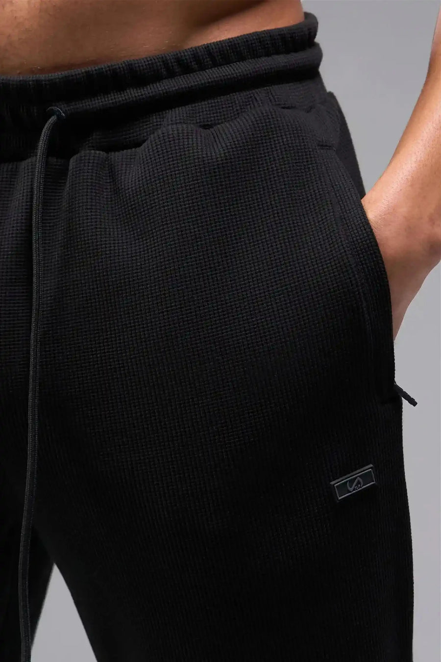 Back View of Black TLF GTS Waffle Tech Joggers, featuring an athletic relaxed fit with zipper pockets designed for all day wear