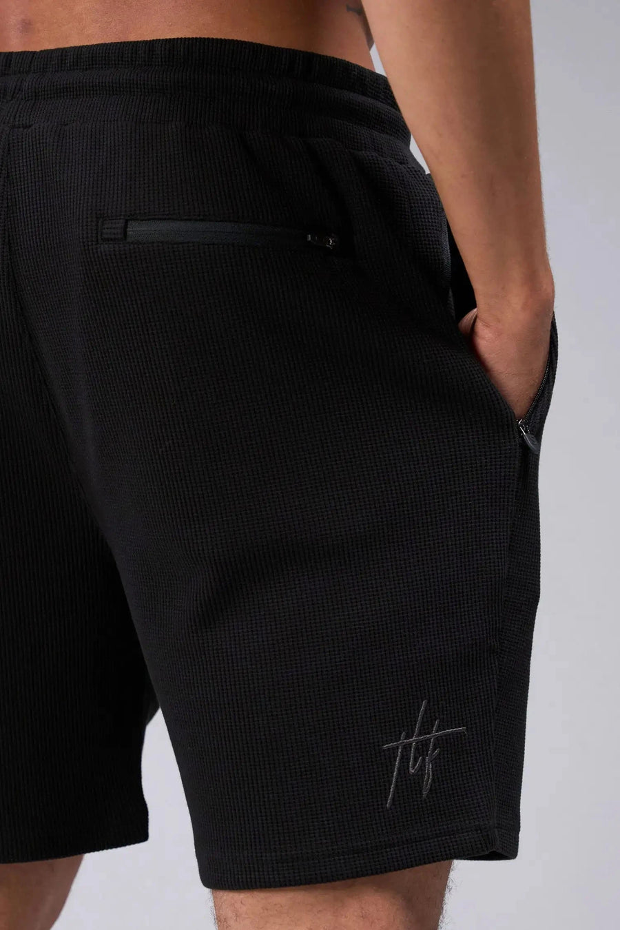 Back View of Black TLF GTS Waffle Tech Shorts, featuring a 6” Inch inseam, an athletic relaxed fit with zipper pockets designed for all day wear