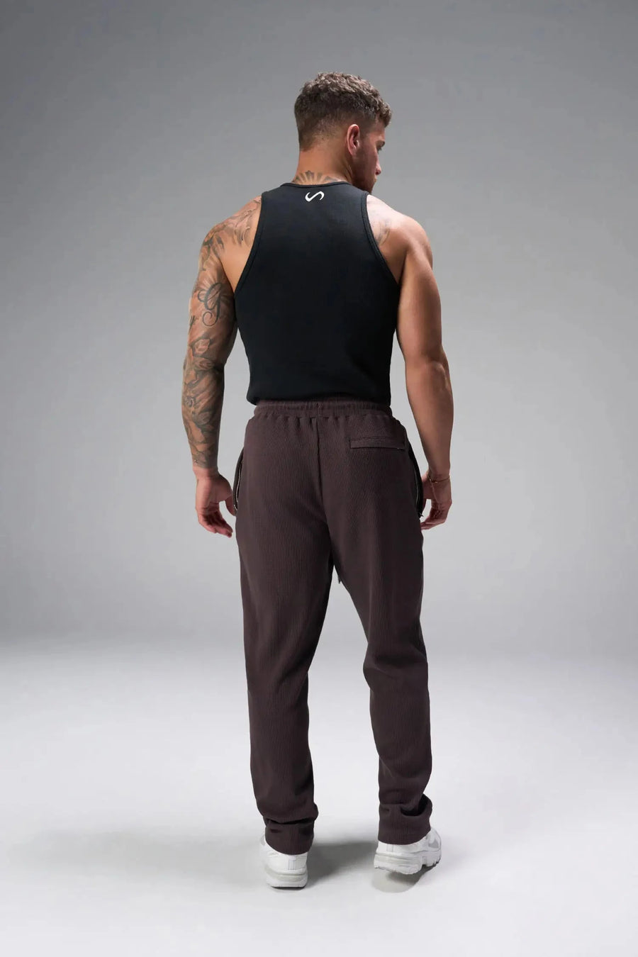 Back View of Brown the TLF GTS Waffle Tech Straight Leg Pants featuring pintuck detailing, zippered pockets and straight leg design