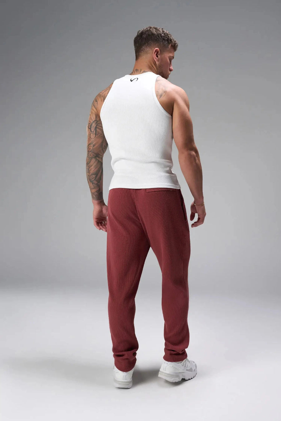 Back View of Red the TLF GTS Waffle Tech Straight Leg Pants featuring pintuck detailing, zippered pockets and straight leg design