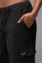 Detail front View of Black the TLF Low Rise Oversized Cargo Joggers featuring a low-rise waistline, oversized & baggy fit and snap button cargo pockets