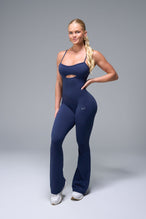 Front View of Blue TLF NeoCloud™ Flare Jumpsuit featuring a built-in low support sports bra with removable pads and adjustable straps