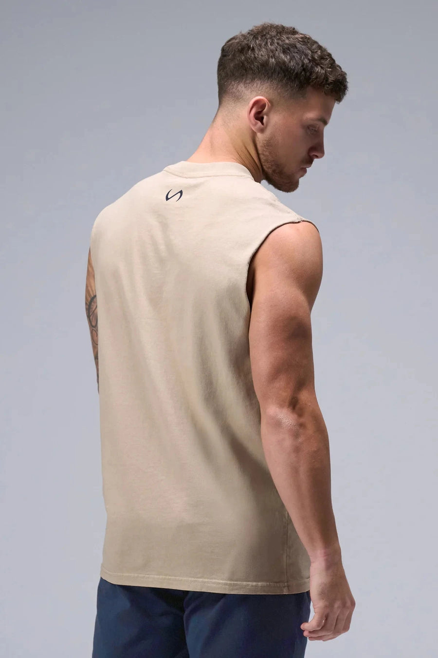 Back View of Tan TLF Property Of Heavy Cotton Muscle Tank featuring a distressed graphic design and raw edge arm holes. 