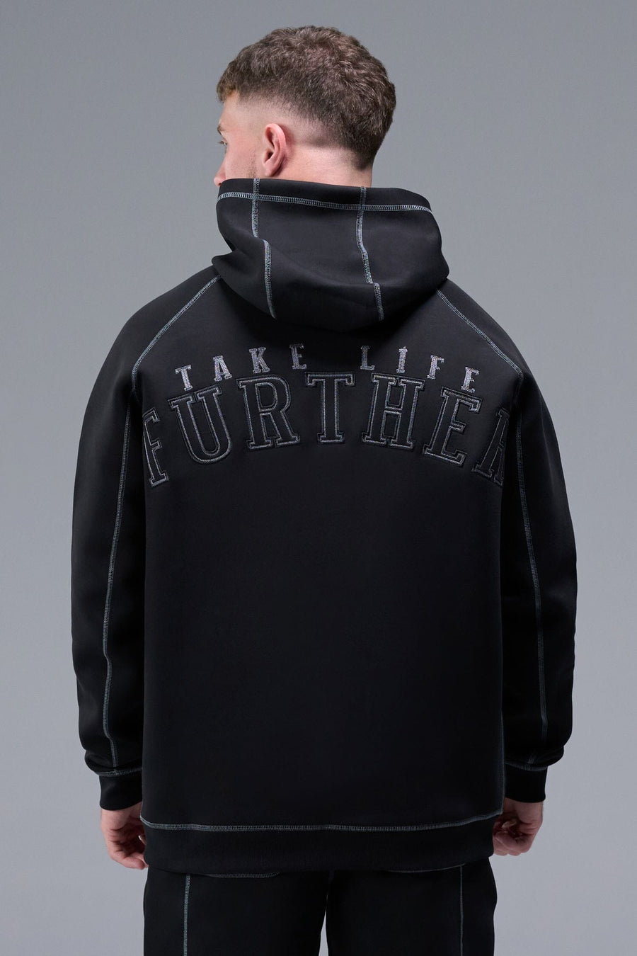 Back View of Black TLF Scuba Tech Contrast Stitch Hoodie, featuring 3 panel hood, Kangaroo pockets and contrast stitching for streetwear aesthetic 