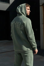 Back View of Green TLF Scuba Tech Contrast Stitch Hoodie, featuring 3 panel hood, Kangaroo pockets and contrast stitching for streetwear aesthetic 