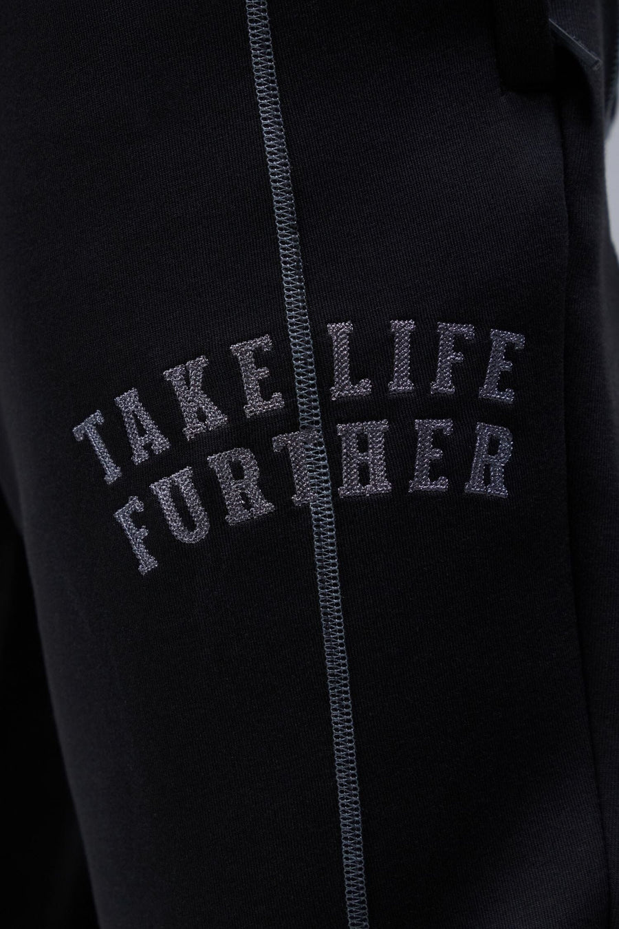 Detail Front View of Black TLF Scuba Tech Contrast Stitch Joggers, featuring side zipper pockets and contrast stitching for streetwear aesthetic 
