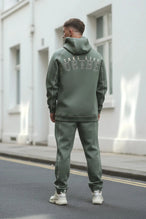 Back View of Green TLF Scuba Tech Contrast Stitch Joggers, featuring side zipper pockets and contrast stitching for streetwear aesthetic 