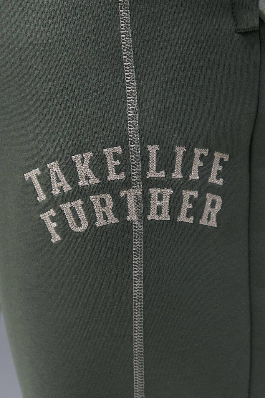 Detail Front View of Green TLF Scuba Tech Contrast Stitch Joggers, featuring side zipper pockets and contrast stitching for streetwear aesthetic 