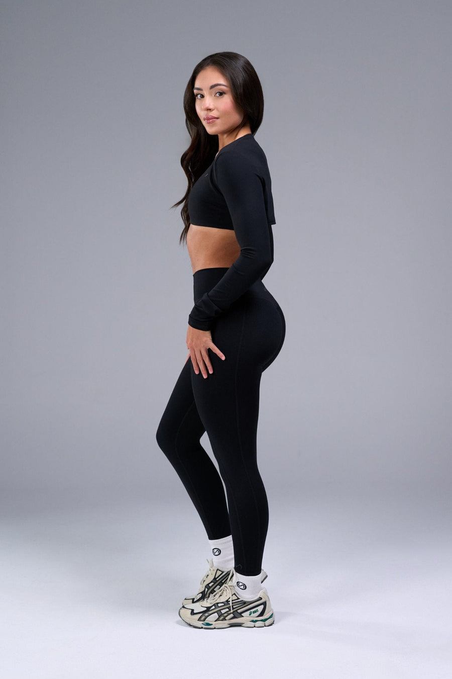 Left Side View of Black Tempo Bolero Shrug featuring thumbholes, designed for workouts and all day wear 