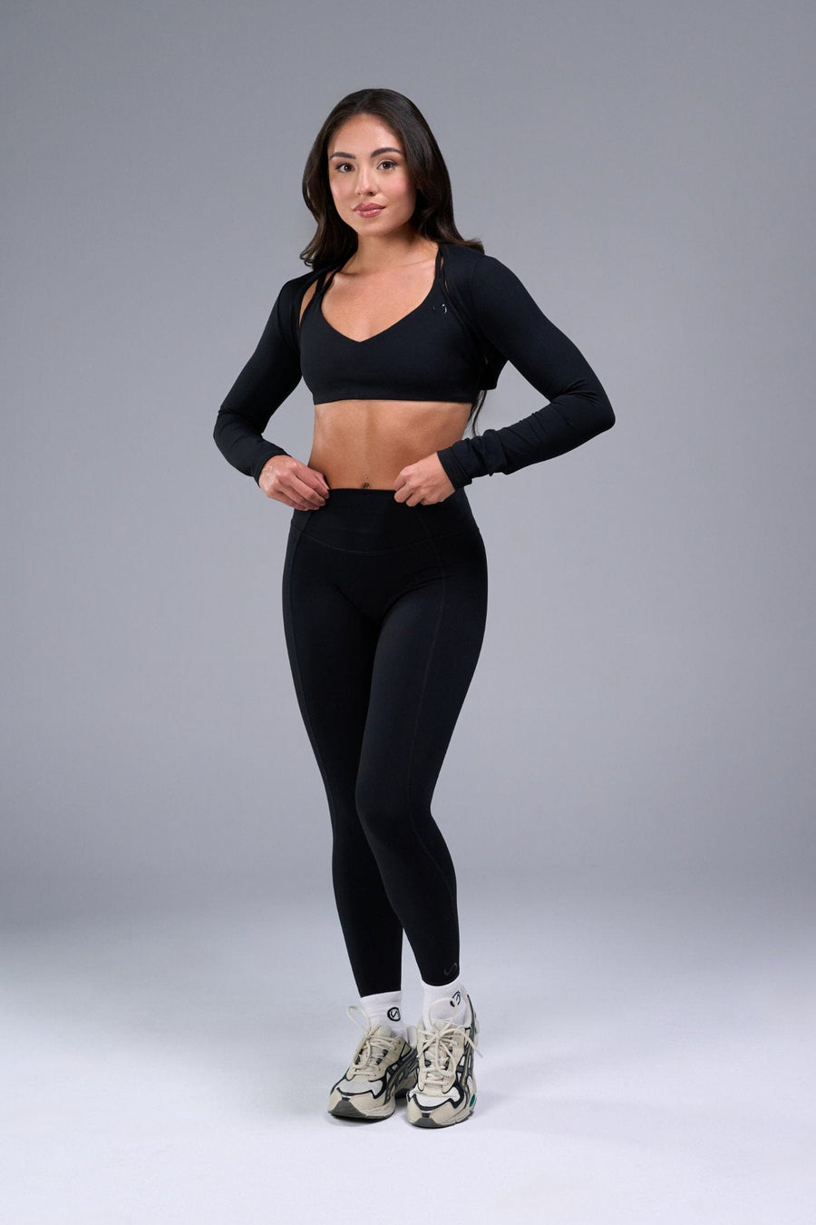 Front View of Black Tempo Bolero Shrug featuring thumbholes, designed for workouts and all day wear 
