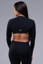 Back View of Black Tempo Bolero Shrug featuring thumbholes, designed for workouts and all day wear 