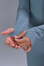 Detail View of Blue TLF Tempo Cropped Zip Up Jacket featuring thumbholes and cropped length for gym and lifestyle wear 