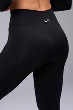 Back View of Black TLF Tempo Flare Leggings, featuring a waist snatching crossover waistband and glute shaping side seam 