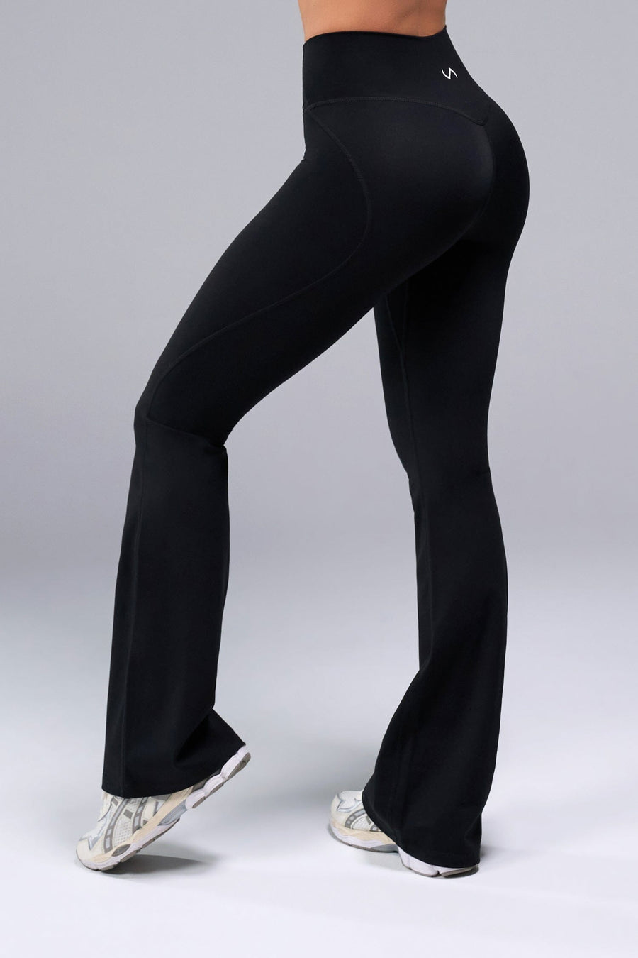 Side View of Black TLF Tempo Flare Leggings, featuring a waist snatching crossover waistband and glute shaping side seam 