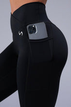 Detail Side View of Black TLF Tempo Side Pocket Leggings, featuring dual side pockets and crossover waistband for performance and functionality 