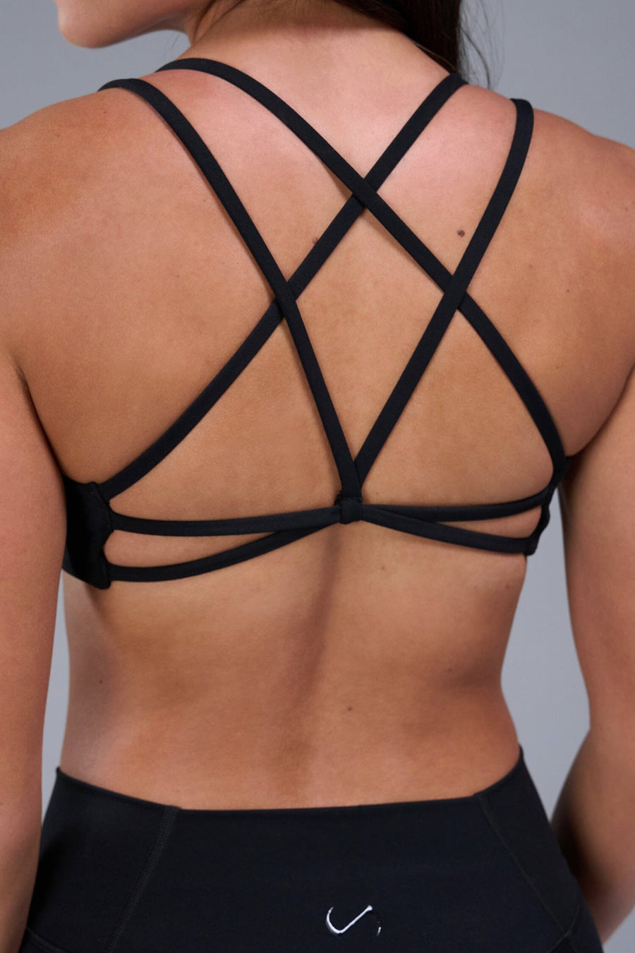 Back View of Black TLF Tempo Strappy Back Sports Bra, featuring a minimal design for the gym and lifestyle wear 