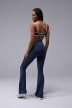 Back View of Blue TLF Tempo Flare Leggings, featuring a waist snatching crossover waistband and glute shaping side seam 