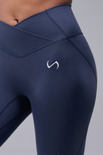 Detail Front View of Blue TLF Tempo Flare Leggings, featuring a waist snatching crossover waistband and glute shaping side seam 