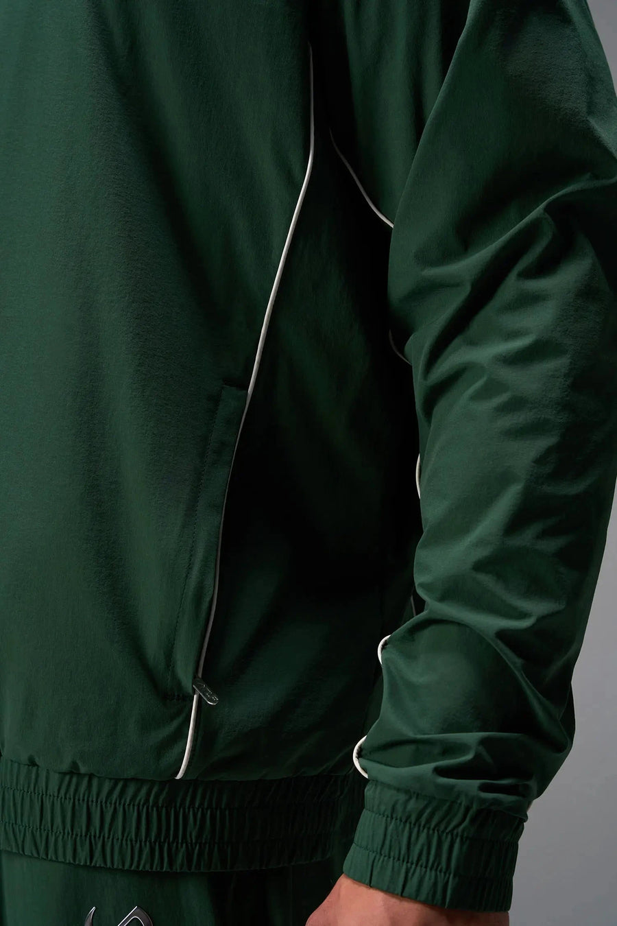 Detail View of Green TLF Track Jacket (Men’s GTS Gym-To-Street Edition) with mesh lining, reflective piping, and premium trims for all-day Gym-To-Street wear. 