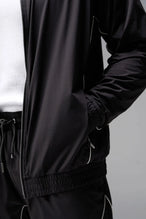 Detail  View of Black TLF Track Jacket (Men’s GTS Gym-To-Street Edition) with mesh lining, reflective piping, and premium trims for all-day Gym-To-Street wear. 